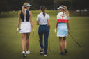 Three women golfers walking on a golf course